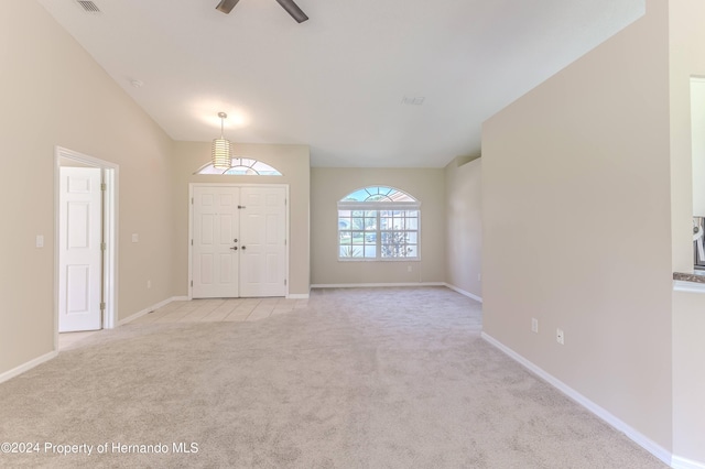 carpeted entrance foyer featuring lofted ceiling and ceiling fan