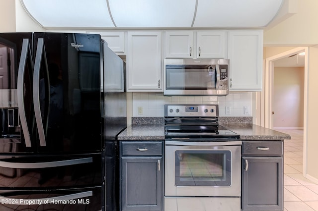 kitchen with white cabinetry, gray cabinetry, decorative backsplash, and appliances with stainless steel finishes