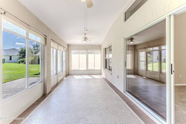 unfurnished sunroom with ceiling fan, lofted ceiling, and a healthy amount of sunlight