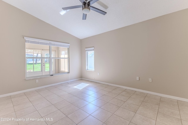 unfurnished room with a textured ceiling, light tile patterned flooring, ceiling fan, and vaulted ceiling