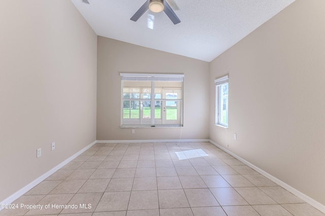 tiled spare room with vaulted ceiling and ceiling fan