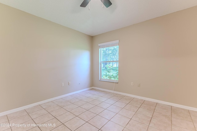 tiled empty room with ceiling fan