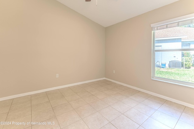 empty room featuring ceiling fan, light tile patterned floors, and lofted ceiling