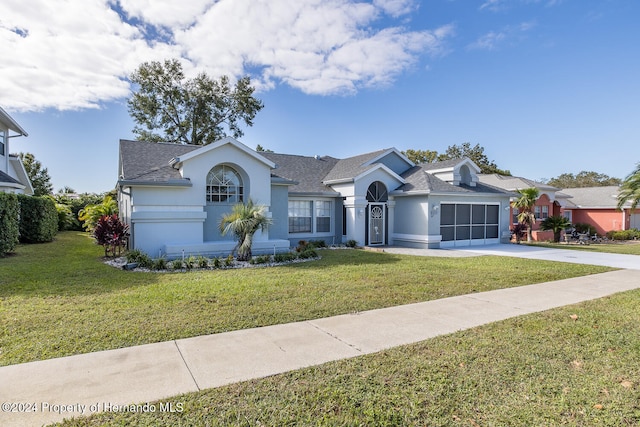 ranch-style house with a garage and a front lawn