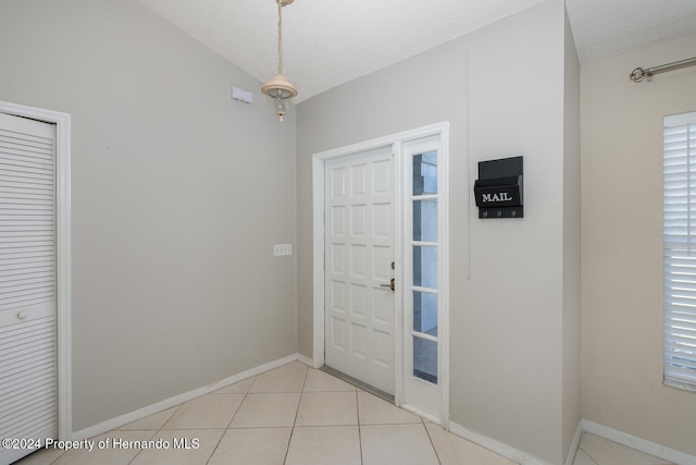 tiled foyer with a textured ceiling