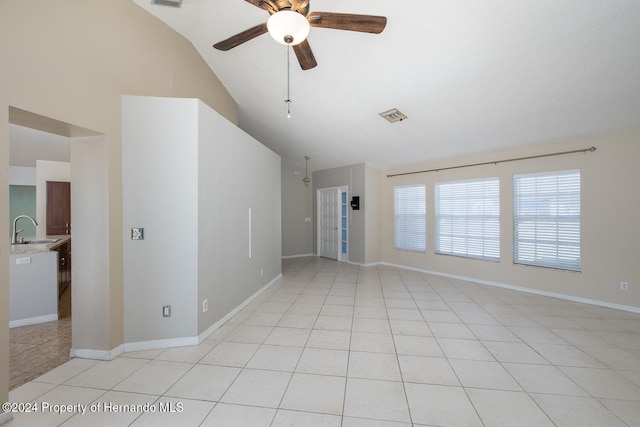 spare room with light tile patterned flooring, ceiling fan, sink, and vaulted ceiling