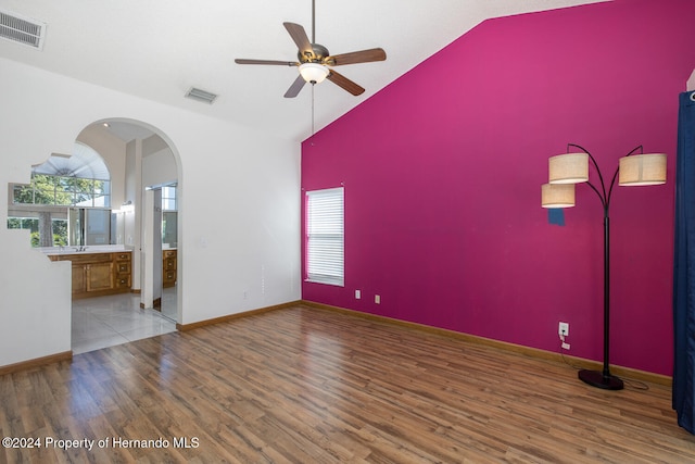 unfurnished room with ceiling fan, wood-type flooring, and high vaulted ceiling