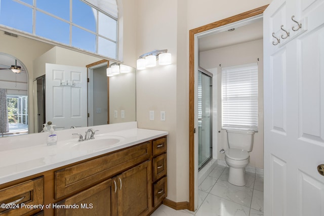 bathroom featuring walk in shower, vanity, toilet, and ceiling fan