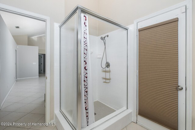 bathroom with tile patterned flooring and tiled shower