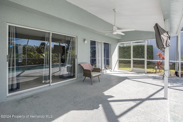 unfurnished sunroom featuring ceiling fan and vaulted ceiling