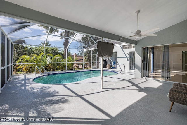 view of pool with a patio, glass enclosure, and ceiling fan