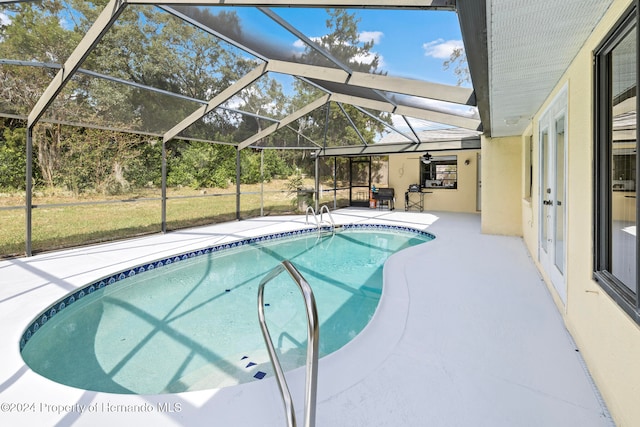 view of pool featuring a patio area and glass enclosure