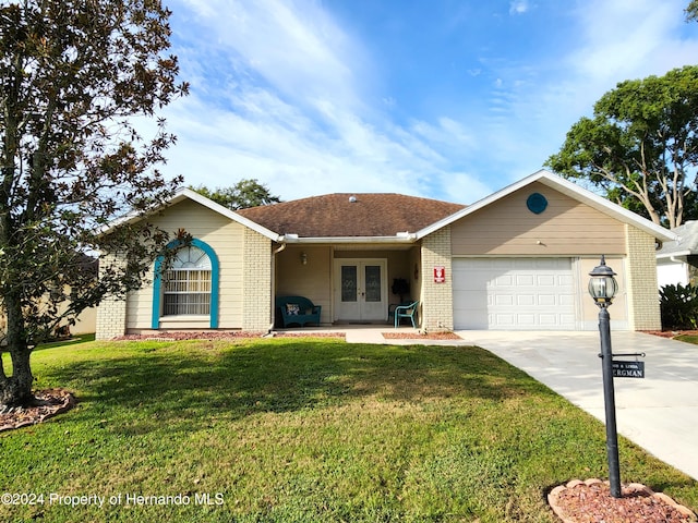 ranch-style house featuring a garage, french doors, and a front lawn