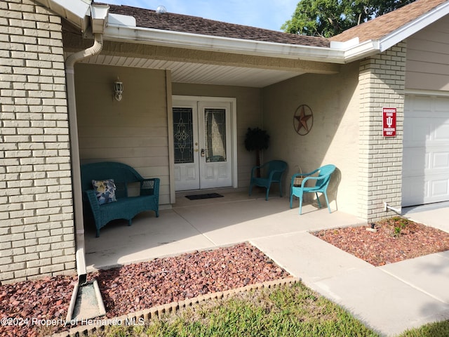 doorway to property featuring french doors and a garage