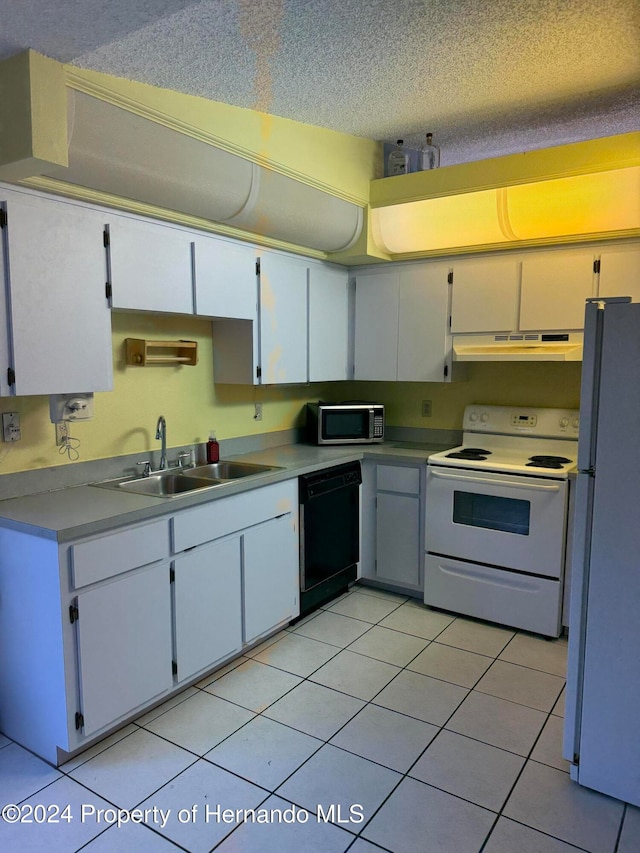 kitchen with a textured ceiling, light tile patterned floors, sink, white cabinets, and white appliances