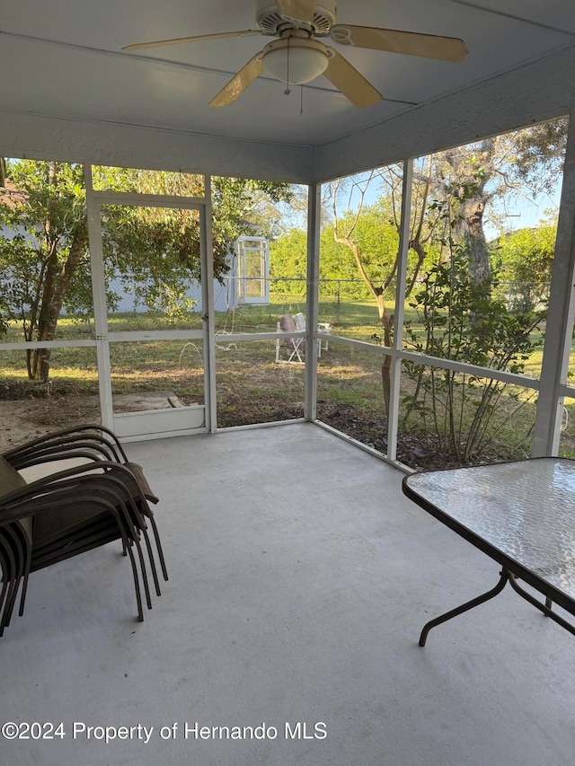 unfurnished sunroom with a wealth of natural light and ceiling fan