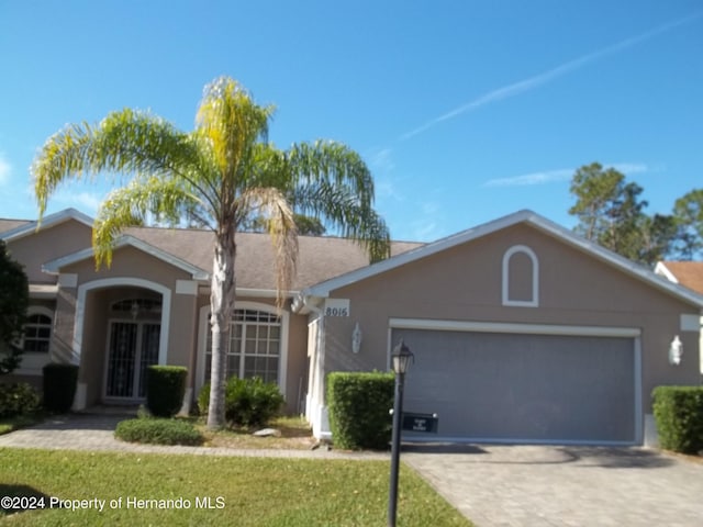 8016 Bellevista Ct, Spring Hill, FL 34606 - single story home featuring an attached garage, stucco siding, a front lawn, and driveway