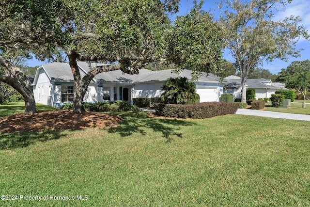 ranch-style home with a garage and a front lawn