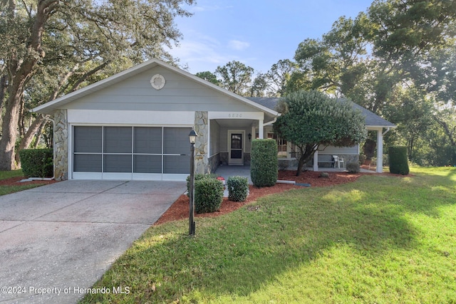 ranch-style home featuring a porch, a front yard, and a garage