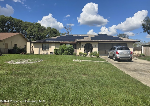 ranch-style house with solar panels and a front lawn