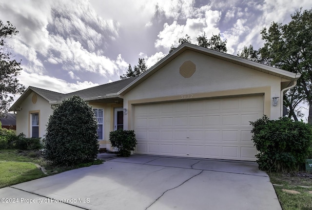 3472 Hartley Rd, Spring Hill, FL 34606 - ranch-style house featuring a garage, concrete driveway, and stucco siding