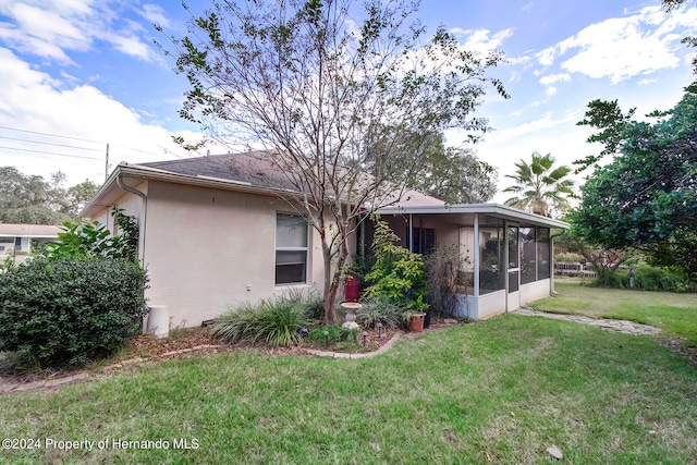 back of property featuring a sunroom and a yard