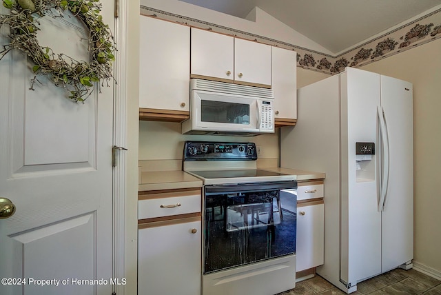 kitchen featuring white appliances, white cabinetry, and lofted ceiling