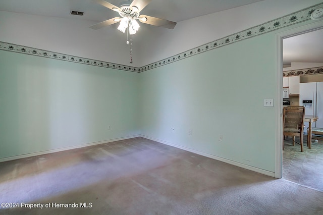 empty room with ceiling fan, carpet flooring, and vaulted ceiling