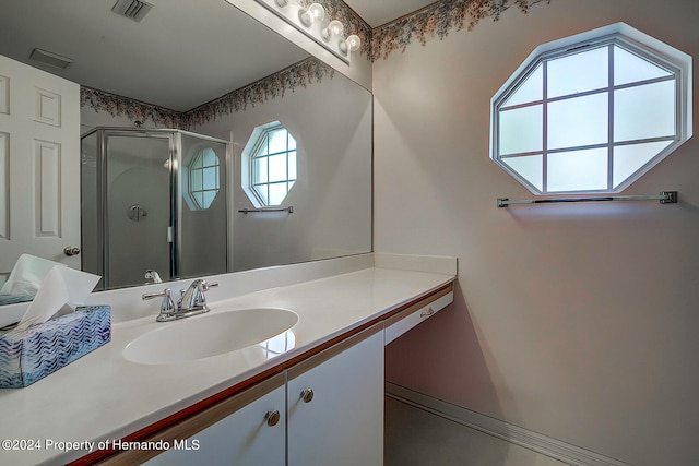 bathroom with an enclosed shower, vanity, and a healthy amount of sunlight