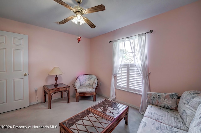 sitting room featuring light colored carpet and ceiling fan