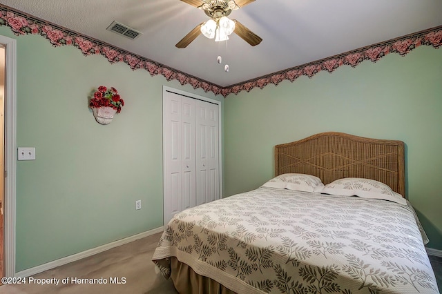 carpeted bedroom featuring ceiling fan and a closet