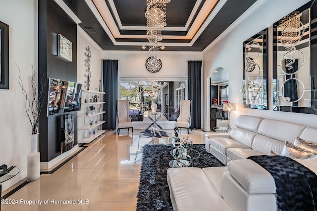 living room featuring ornamental molding, a chandelier, and a tray ceiling