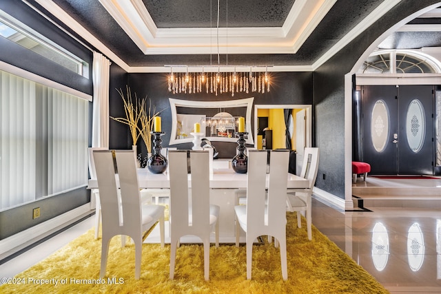 dining area featuring a raised ceiling, an inviting chandelier, and crown molding