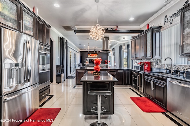 kitchen featuring stainless steel appliances, an inviting chandelier, hanging light fixtures, crown molding, and a kitchen island