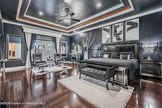 bedroom featuring crown molding, dark wood-type flooring, ceiling fan, and a raised ceiling