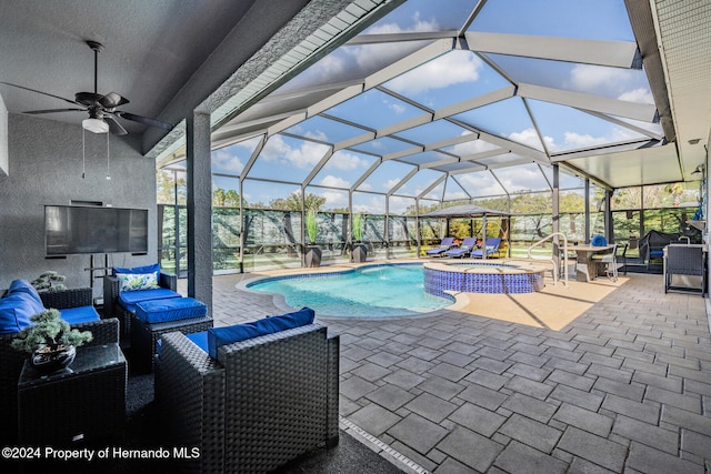 view of pool featuring an outdoor hangout area, glass enclosure, a patio, and ceiling fan