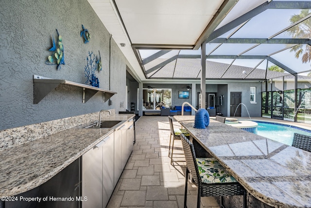 kitchen with light stone countertops, sink, and vaulted ceiling