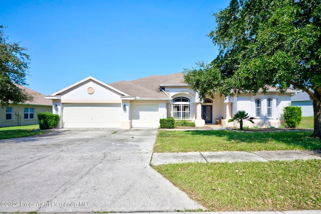 view of front of house featuring a garage and a front lawn