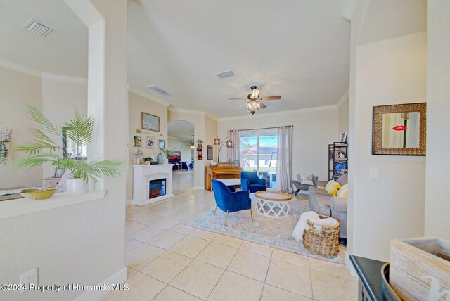 tiled living room featuring ceiling fan and ornamental molding