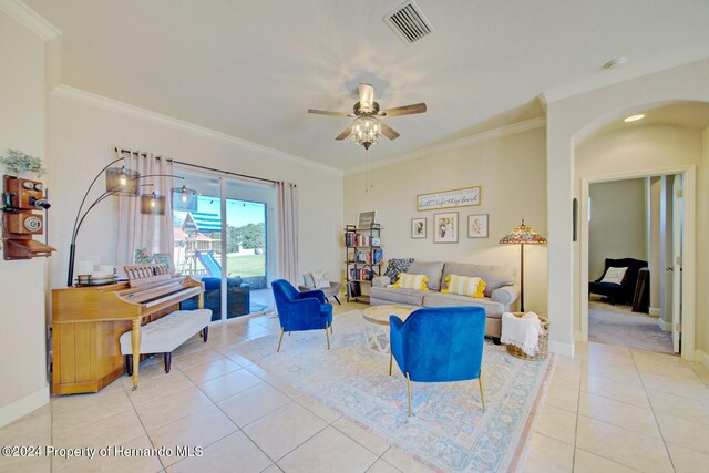 living room featuring ceiling fan, light tile patterned flooring, and ornamental molding