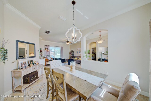 tiled dining area with crown molding and a notable chandelier