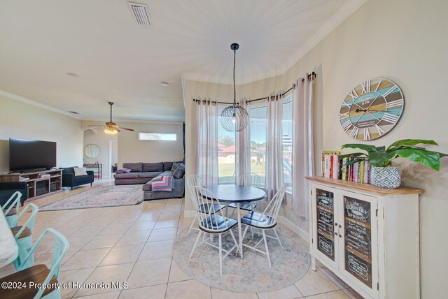 dining area featuring ceiling fan, light tile patterned floors, and crown molding