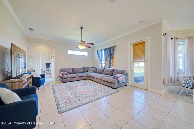 living room featuring ceiling fan, a healthy amount of sunlight, ornamental molding, and light tile patterned floors