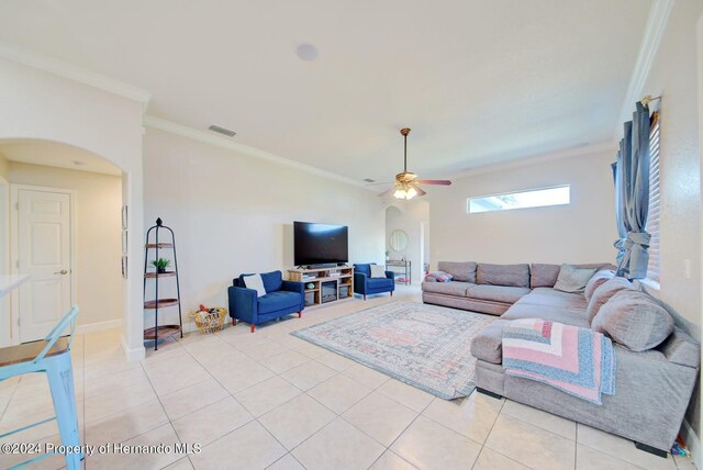 tiled living room with ceiling fan and ornamental molding