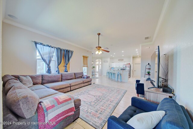 tiled living room featuring crown molding, plenty of natural light, and ceiling fan