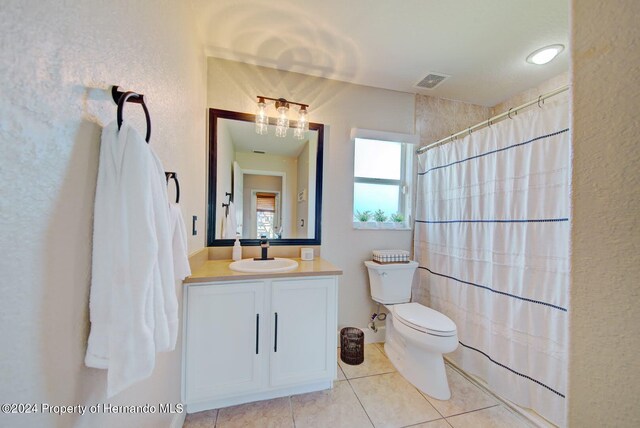 bathroom featuring tile patterned flooring, vanity, curtained shower, and toilet