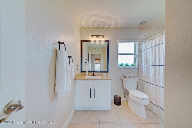 bathroom featuring tile patterned floors, curtained shower, vanity, and toilet