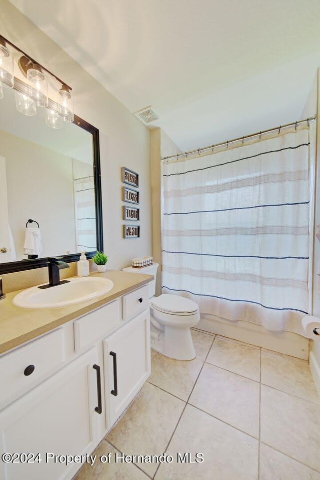 full bathroom with tile patterned flooring, vanity, shower / bath combination with curtain, and toilet