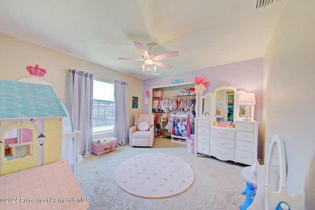 carpeted bedroom featuring ceiling fan and a closet