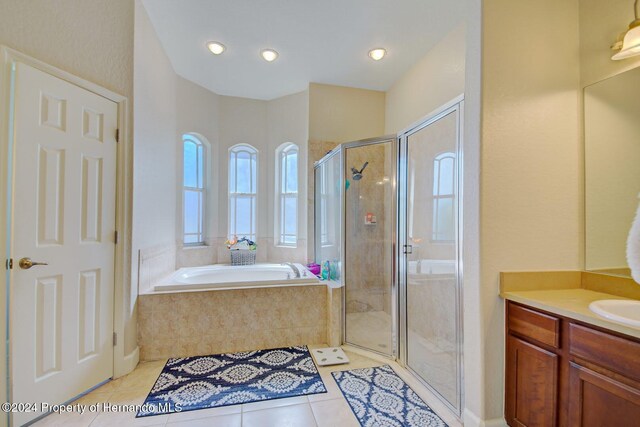 bathroom with tile patterned floors, vanity, and plus walk in shower